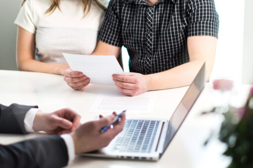 People having meeting about mortgage, bank loan, buying house, insurance or apartment rent. Woman, man and lawyer preparing prenupitial agreement in office. Person reading real estate paper contract.